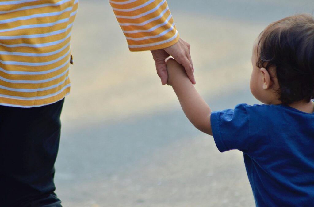 endho-child-5033381_1280 person holding a child's hand