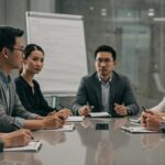a professional mediation session unfolds in a modern conference room, with attentive individuals engaged in a focused discussion around a sleek table, emphasizing the serious yet constructive atmosphere of texas divorce mediation services.