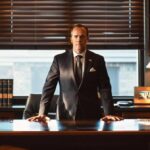 a confident texas divorce attorney stands at a sleek, modern office desk, illuminated by soft, focused lighting, as they engage in a thoughtful discussion about spousal support, surrounded by legal books and framed certificates that convey professionalism and expertise.