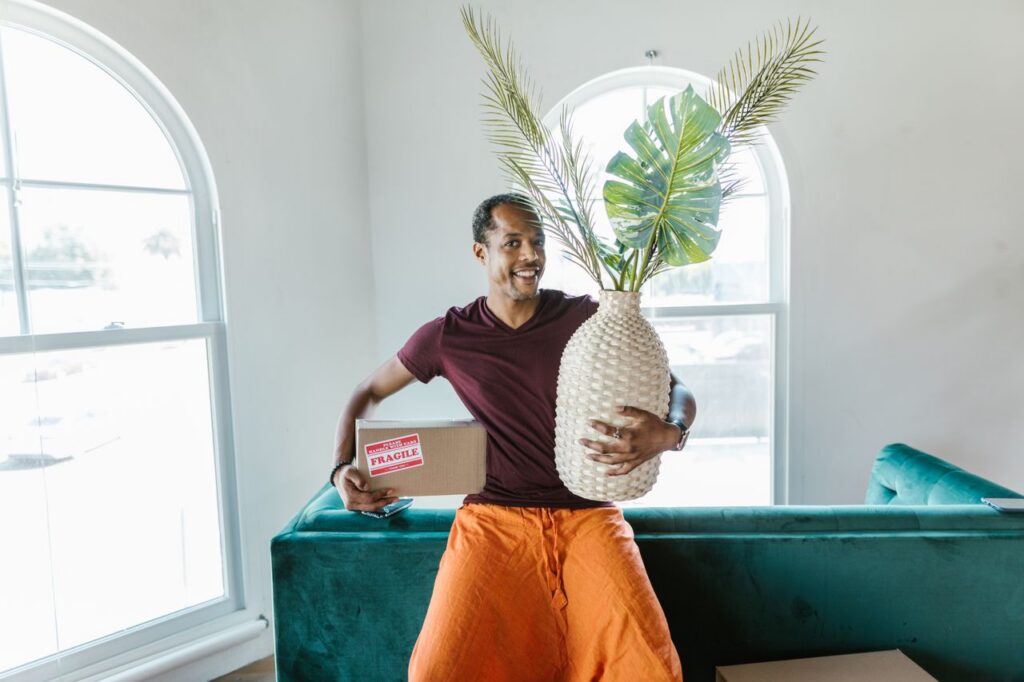 a man carrying a vase and box