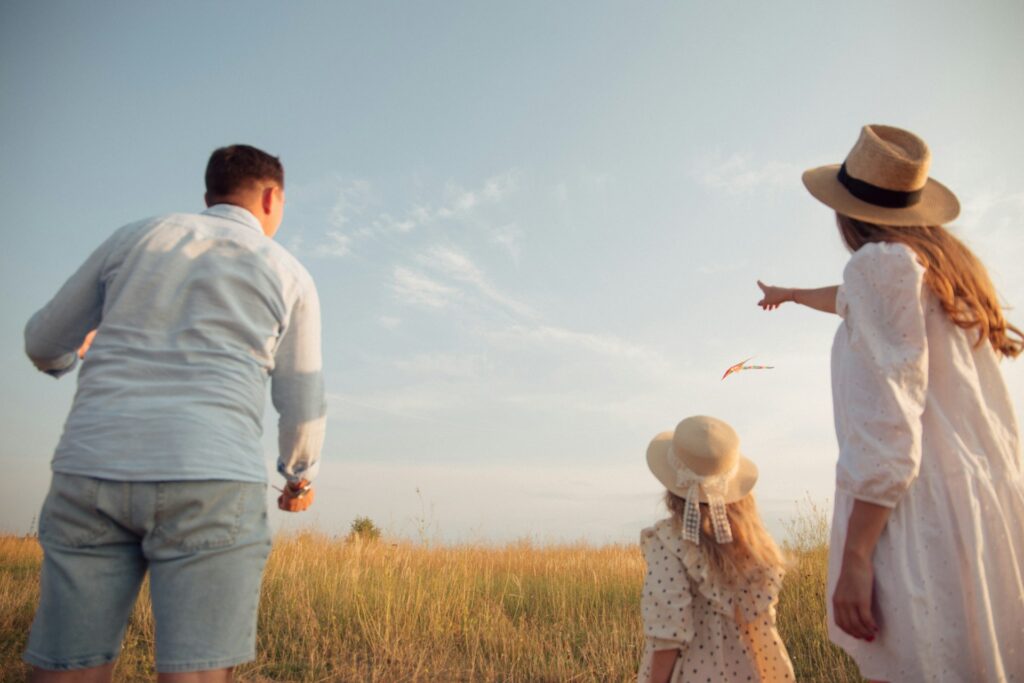 man, woman and child on a field