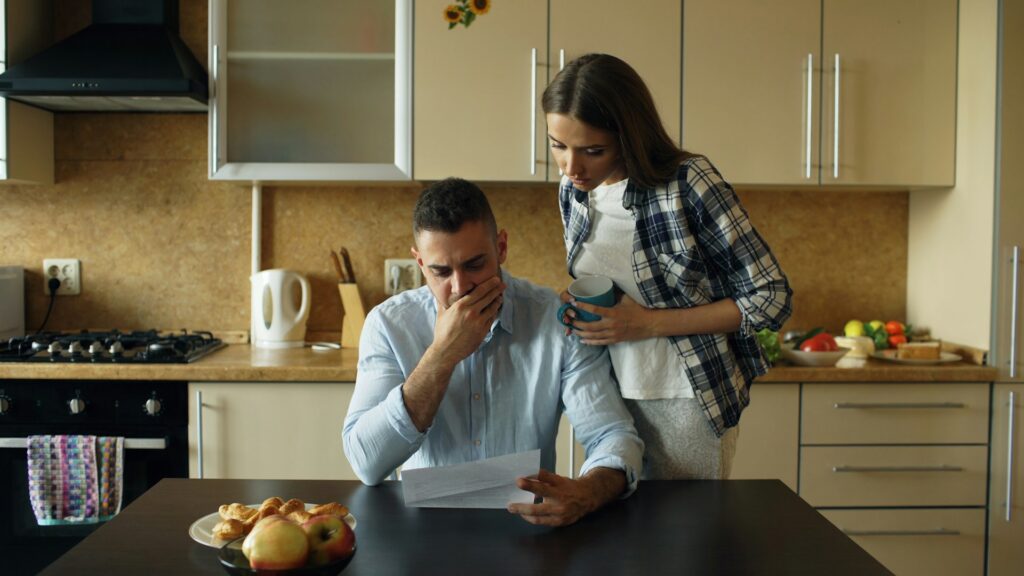 couple looking stressed reading a letter
