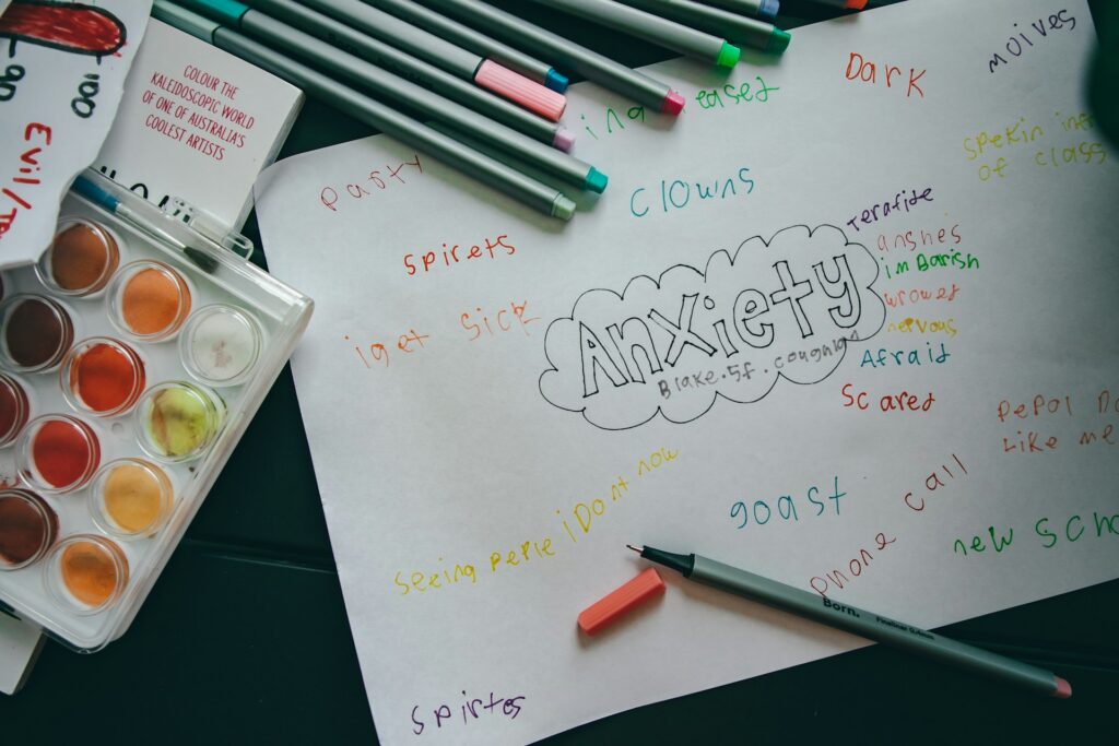 pens and scribbles on white paper with the word "anxiety"