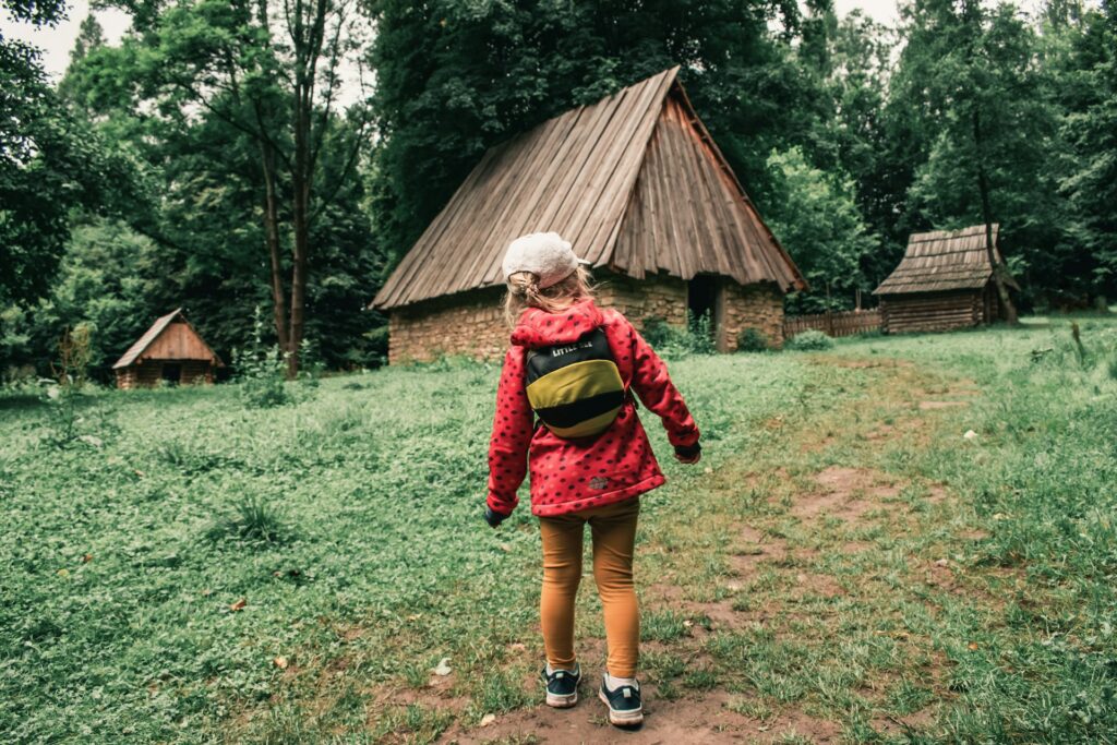 jacek-poblocki-OCyGtJG0U7k-unsplash girl walking towards a hut