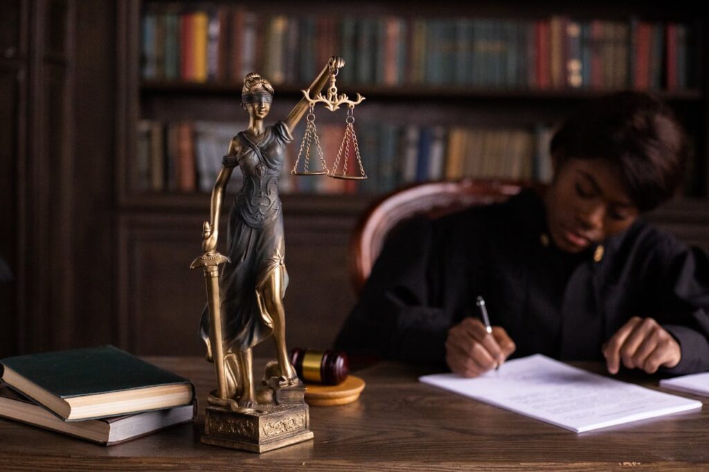lady justice figurine and judge writing on desk