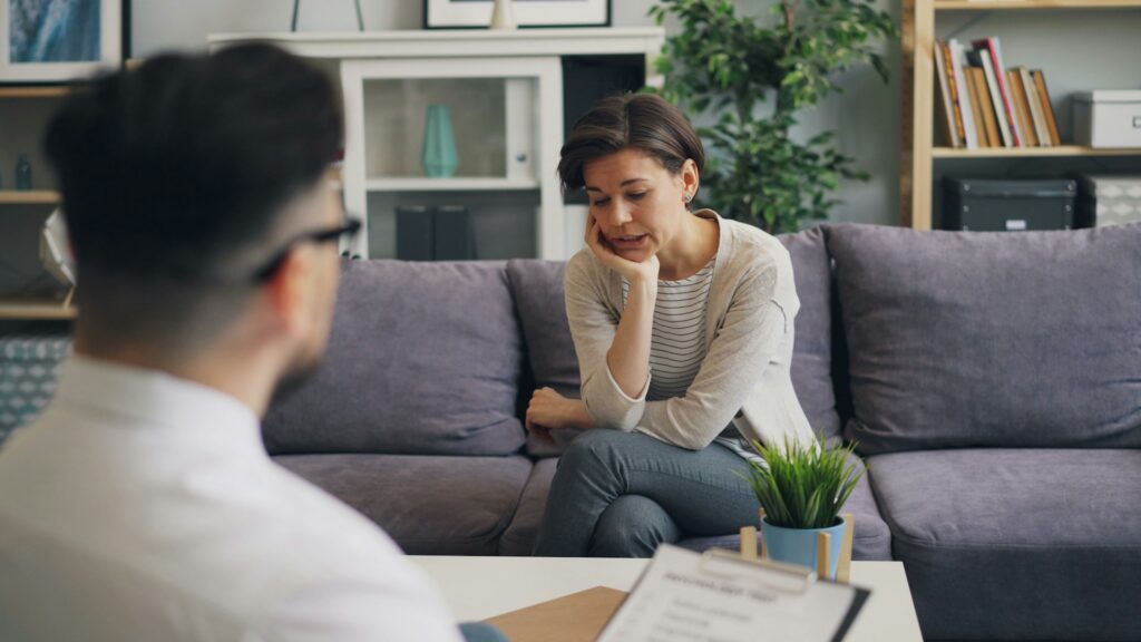 vitaly-gariev-SktdARcCuys-unsplash a woman sitting on a couch talking to a man