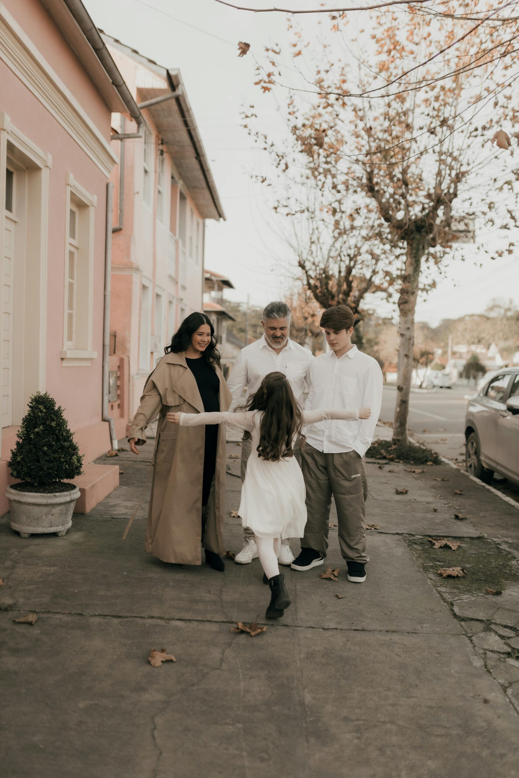 A family enjoying a walk on a quiet street during a warm fall day.