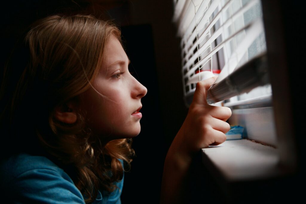 alexander-grey-dW6FP74AhIU-unsplash girl looking through a window
