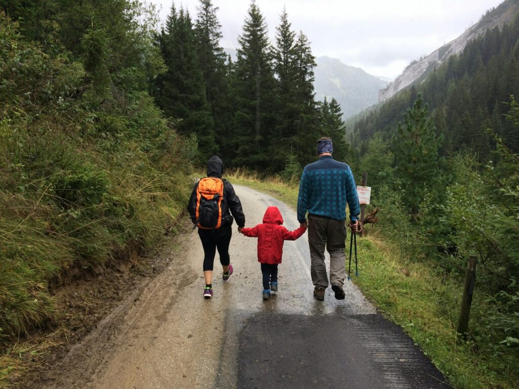 alberto-casetta-REKXJ7JhwiI-unsplash man, woman, and child walking along a dirt road