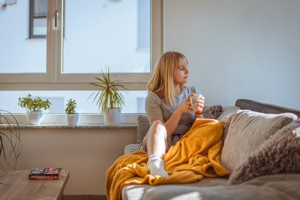 julian-bock-r_K7rCRTeUI-unsplash woman sitting on a couch holding a mug