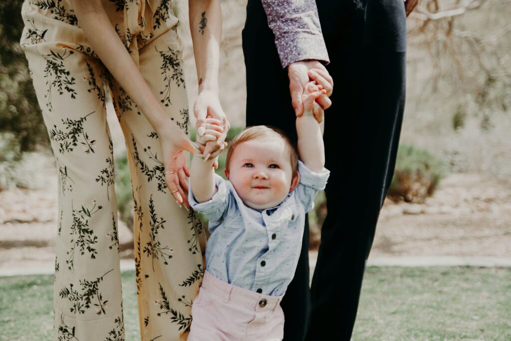 kenny-eliason-uaQpinemVoo-unsplash man and woman holding the hands of a child