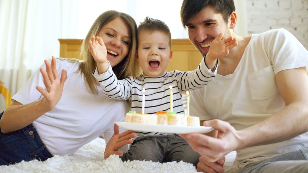 child celebrating birthday with parents
