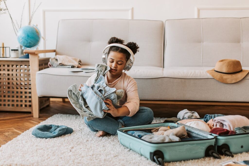 child packing stuff in suitcase