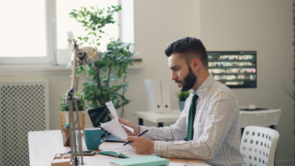 vitaly-gariev-g_k5yBcyS98-unsplash man at the office looking at documents
