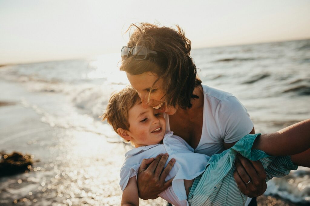 xavier-mouton-photographie-ry_sD0P1ZL0-unsplash mother carrying a child in the shore