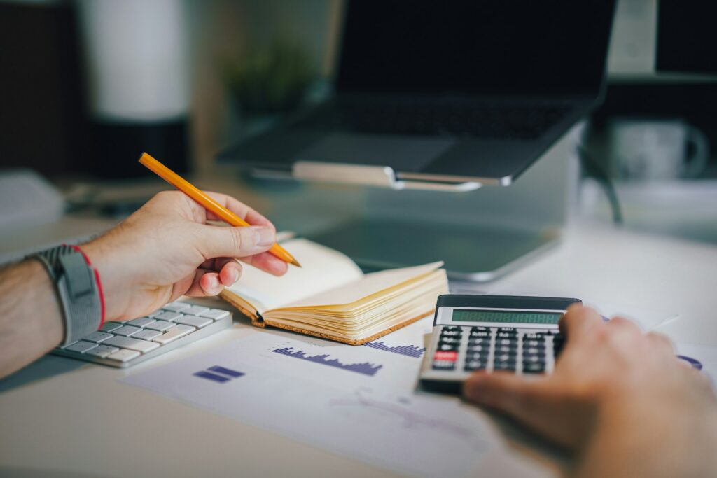 person using calculator and notebook