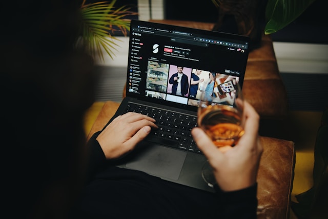 A person accessing videos online while holding a drink