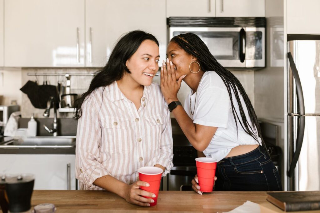 woman whispering to another woman