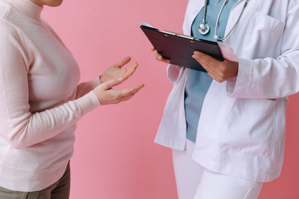 woman talking to a doctor holding a clipboard