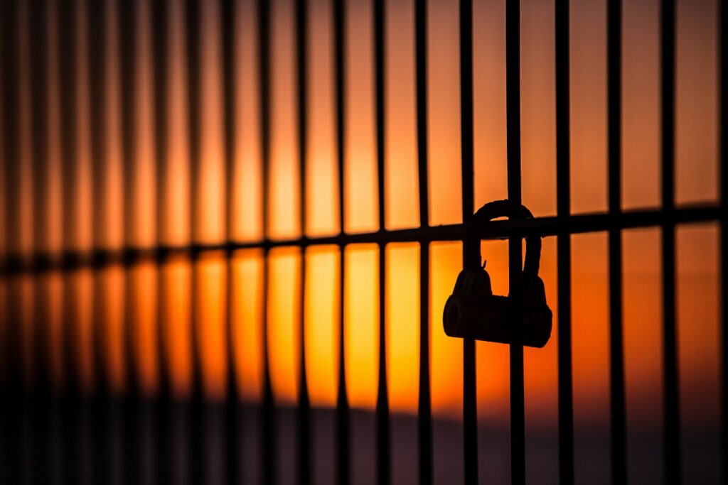 saad-chaudhry-AqHIWSsF24I-unsplash silhouette of padlock on window grills
