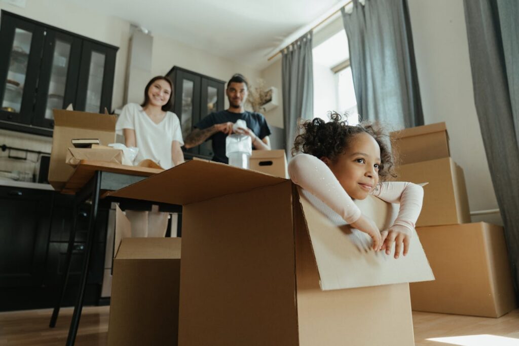 girl playing in a box amid moving in a new home