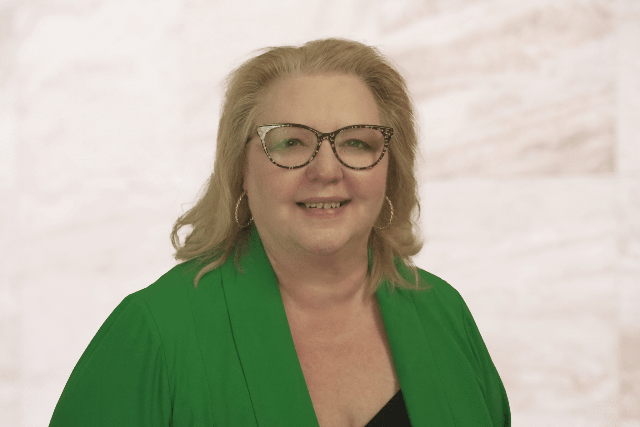Deborah Coleman, attorney at Bryan Fagan PLLC, smiling in a green blazer with glasses, representing criminal defense expertise.