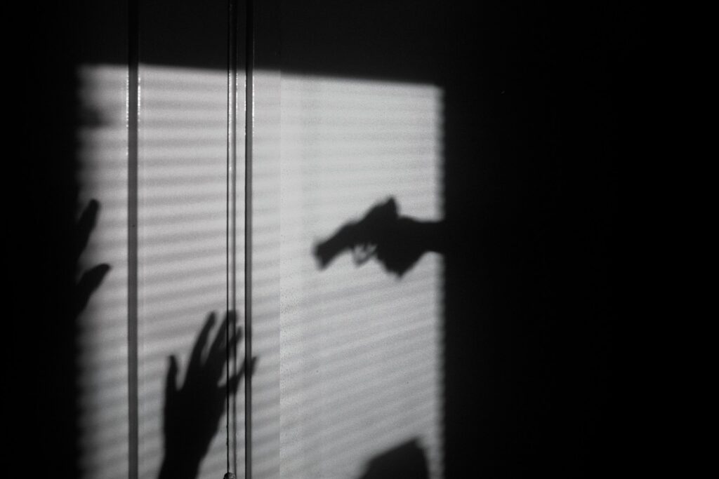 silhouette of a gun pointed to a person