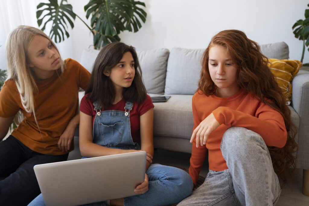 Children on laptop discussing each other about Parental alianation