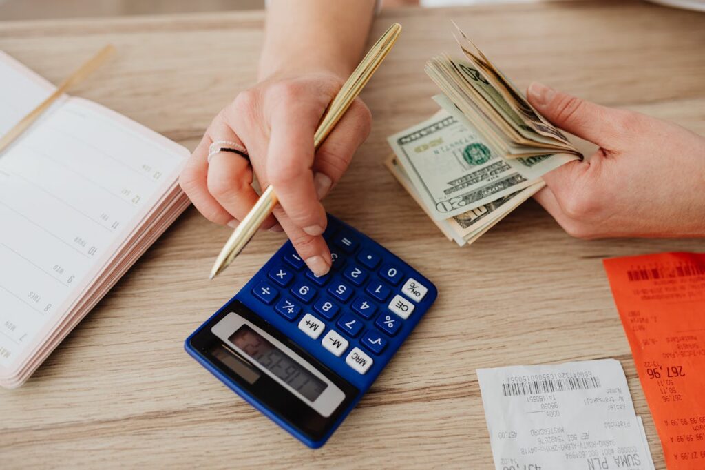 person counting cash and using calculator