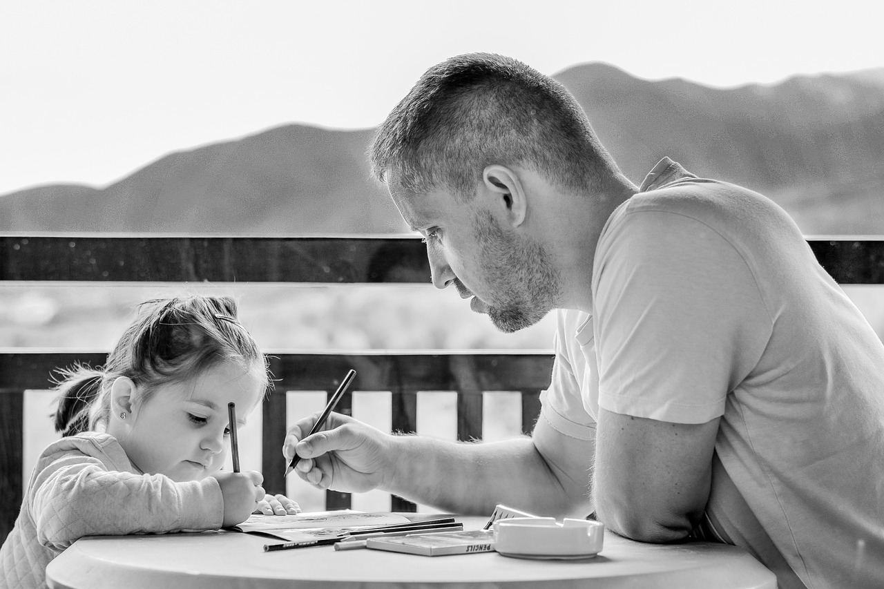 A father teaching his young daughter how to write