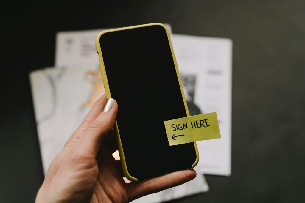 phone with sticky note that says "sign here"