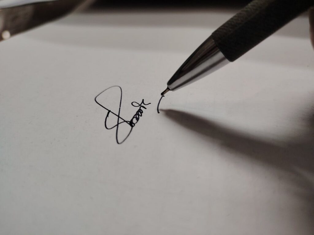 close up of pen writing signature