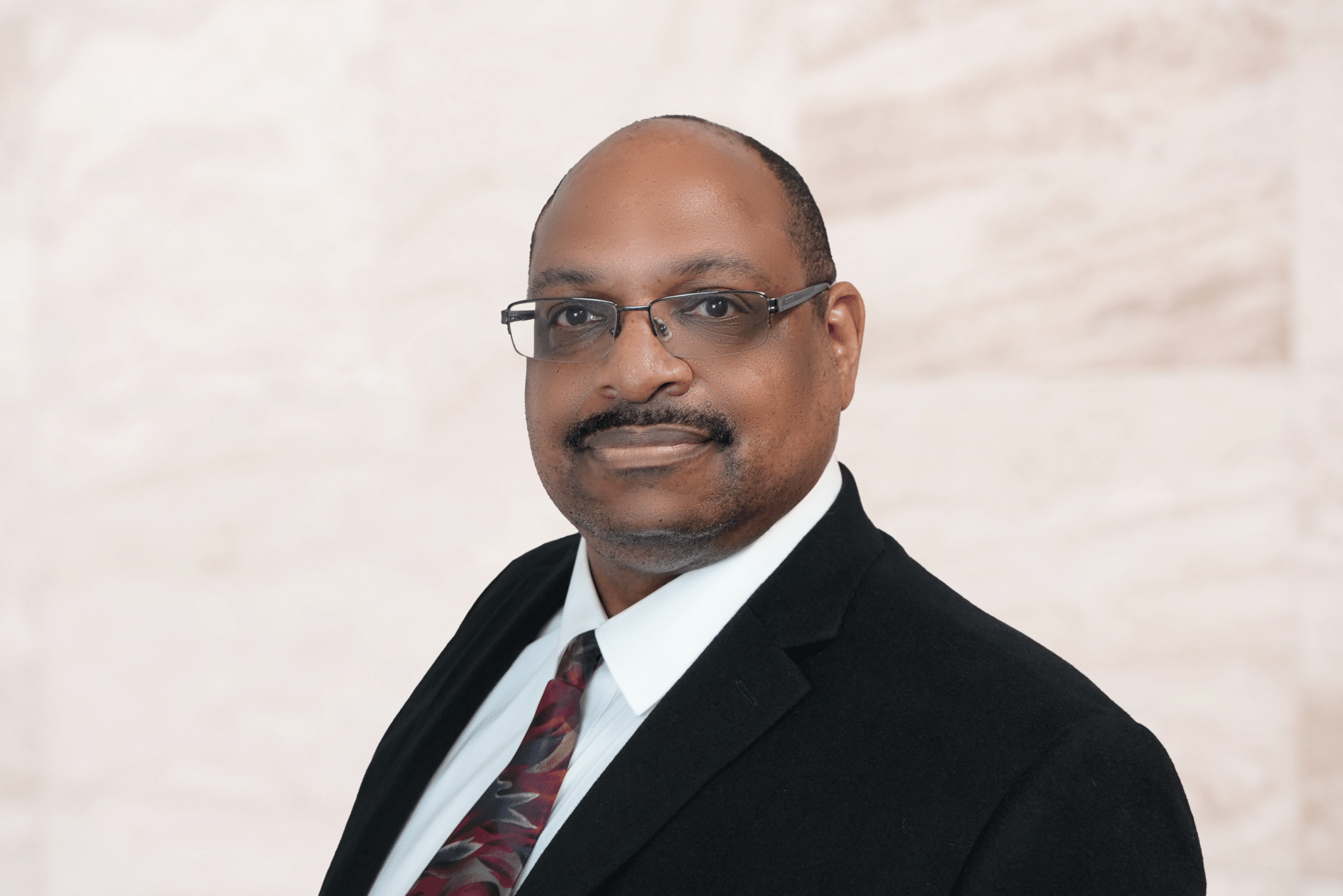 Byron Shaw, attorney at Bryan Fagan PLLC, wearing a suit and tie, smiling confidently against a neutral background, representing criminal defense expertise.