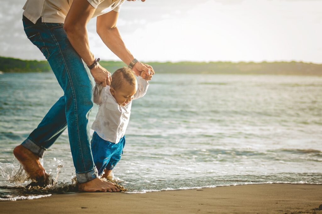 Father walking a child at the beach