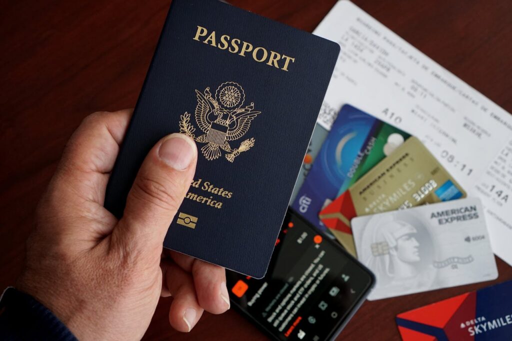 person holding passport and credit cards