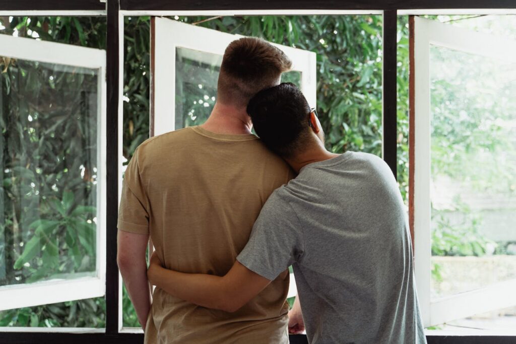 gay couple looking out a window
