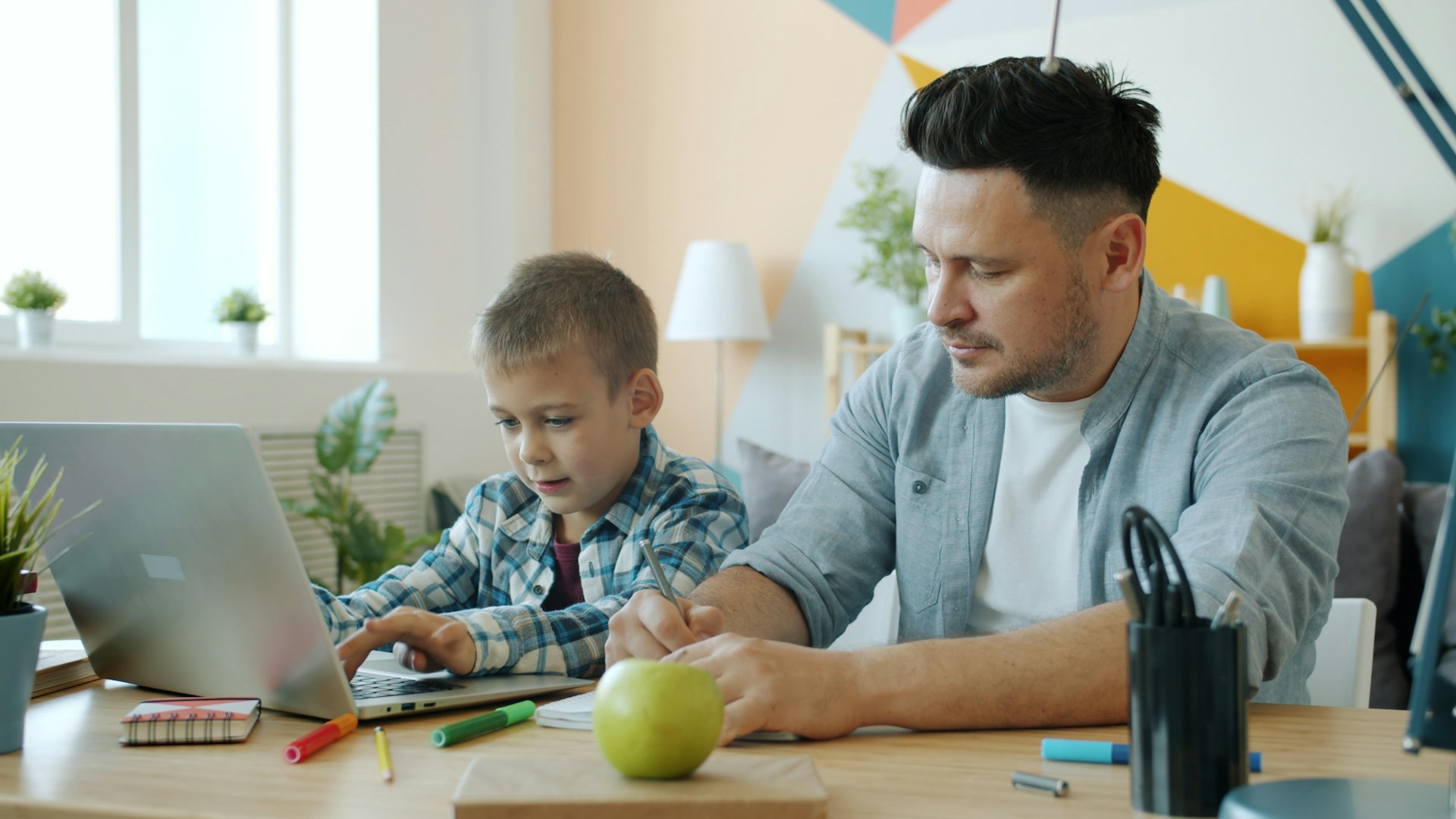 father and son working together on a laptop