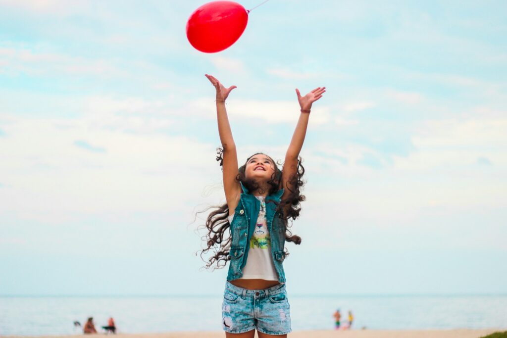 Child playing with a balloon on a beach