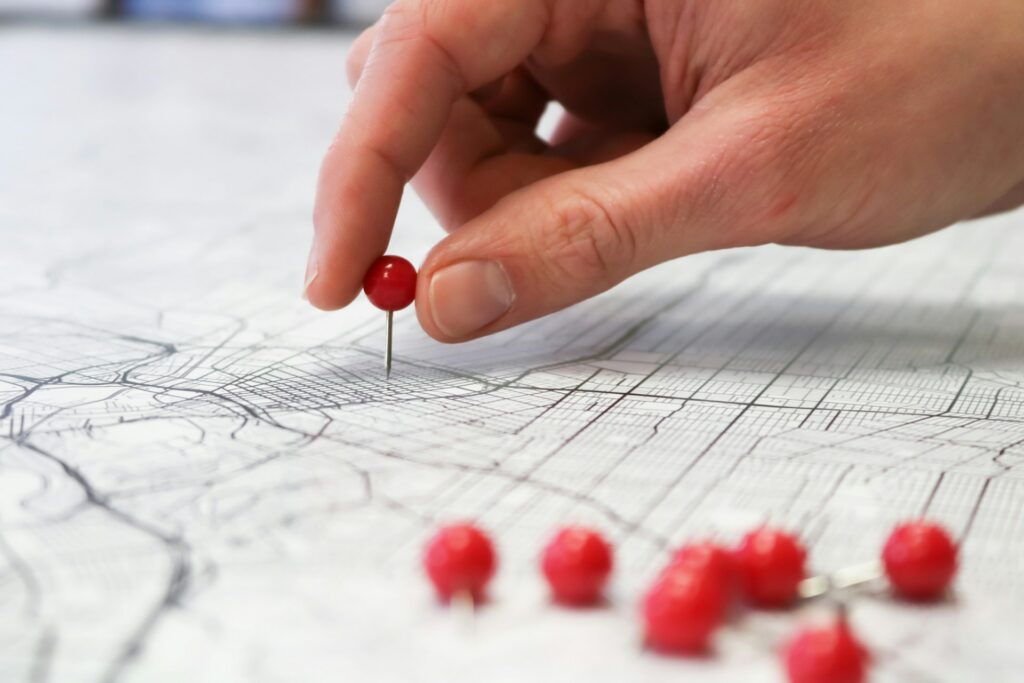 person putting pins on map