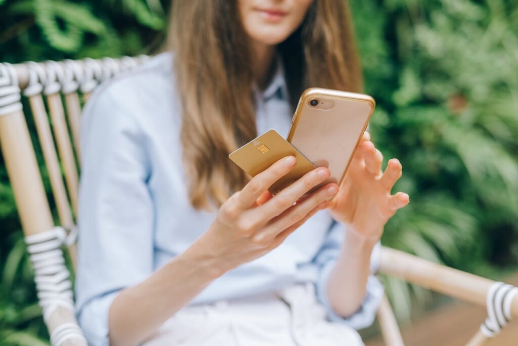 woman holding credit card and smartphone