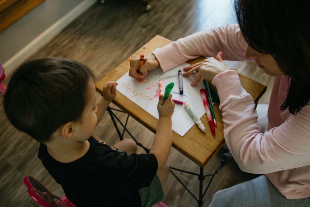 adult helping a child in coloring