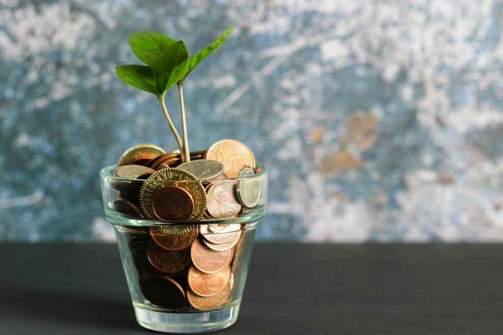 coins inside a glass with plant
