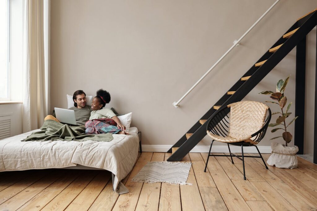 couple using laptop in bed