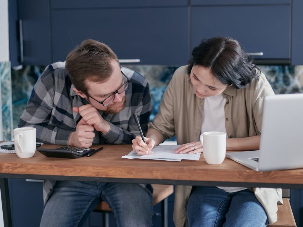 woman writing while a man looks