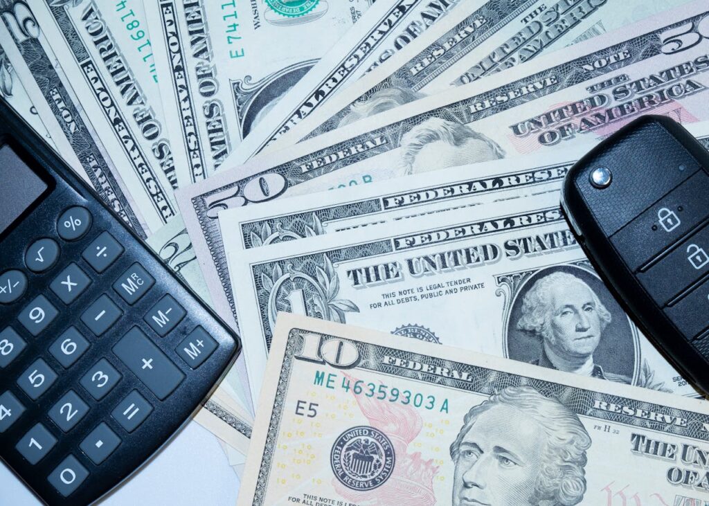 dollars, calculator and car key