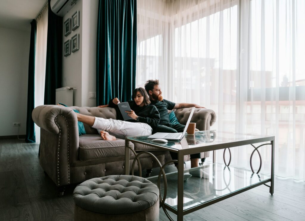 toa-heftiba-XFdFdmVYe3Y-unsplash A couple at home relaxing on the couch