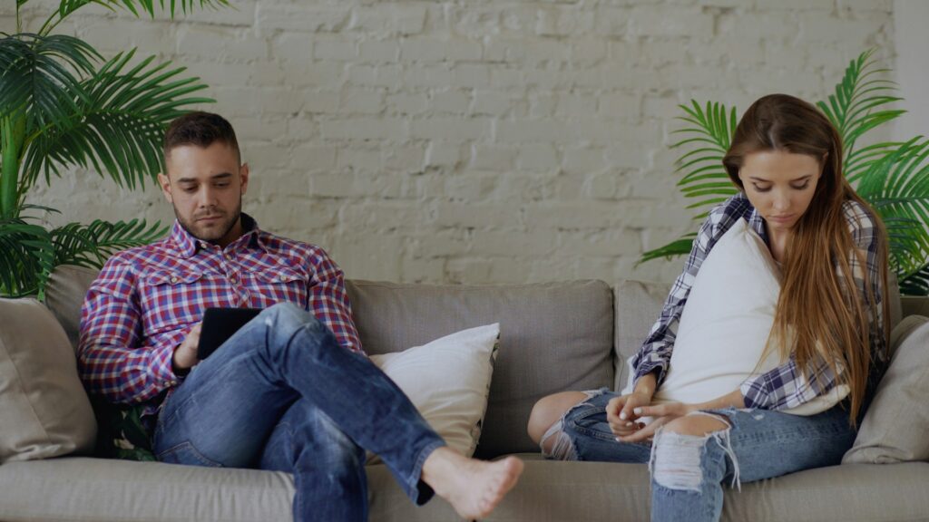 couple sitting on a sofa with some distance