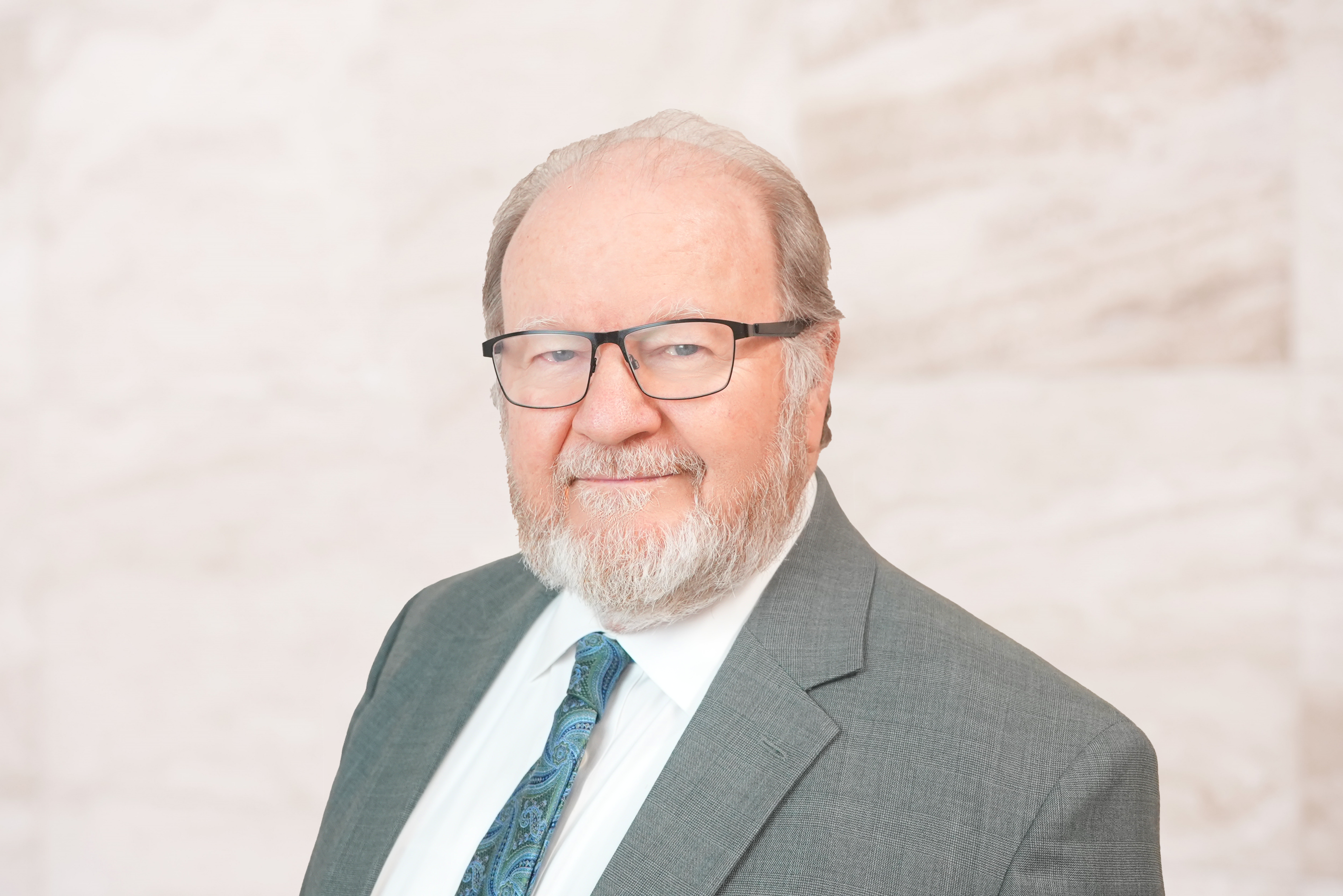 Bruce Buskirk, criminal defense attorney at Bryan Fagan PLLC, wearing a suit and tie, with a professional demeanor against a neutral background.