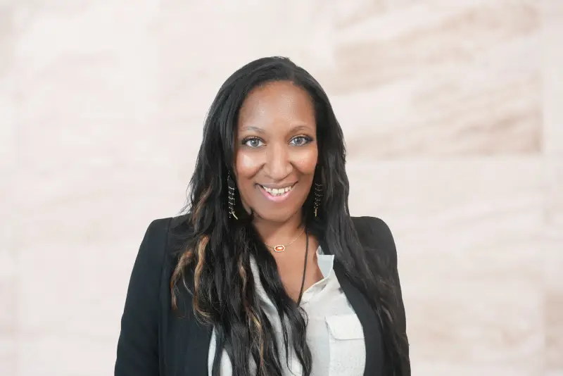 Professional headshot of a smiling female attorney with long dark hair wearing a blazer.