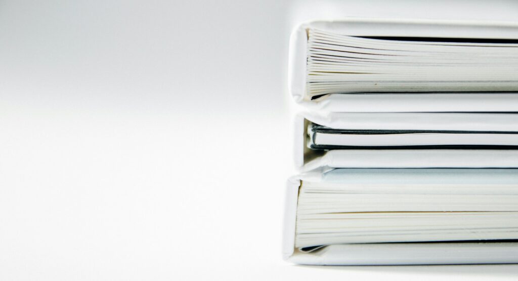 beatriz-perez-moya-XN4T2PVUUgk-unsplash a stack of thick folders on a white surface